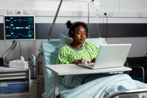 woman in hospital bed using laptop