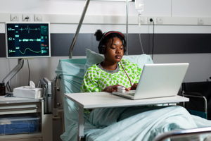 Woman In Hospital Bed Using Laptop