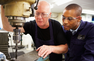 Teacher And Student Using A Drill