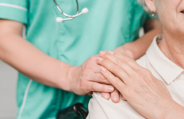 Healthcare Worker With Hands On Patients Shoulder